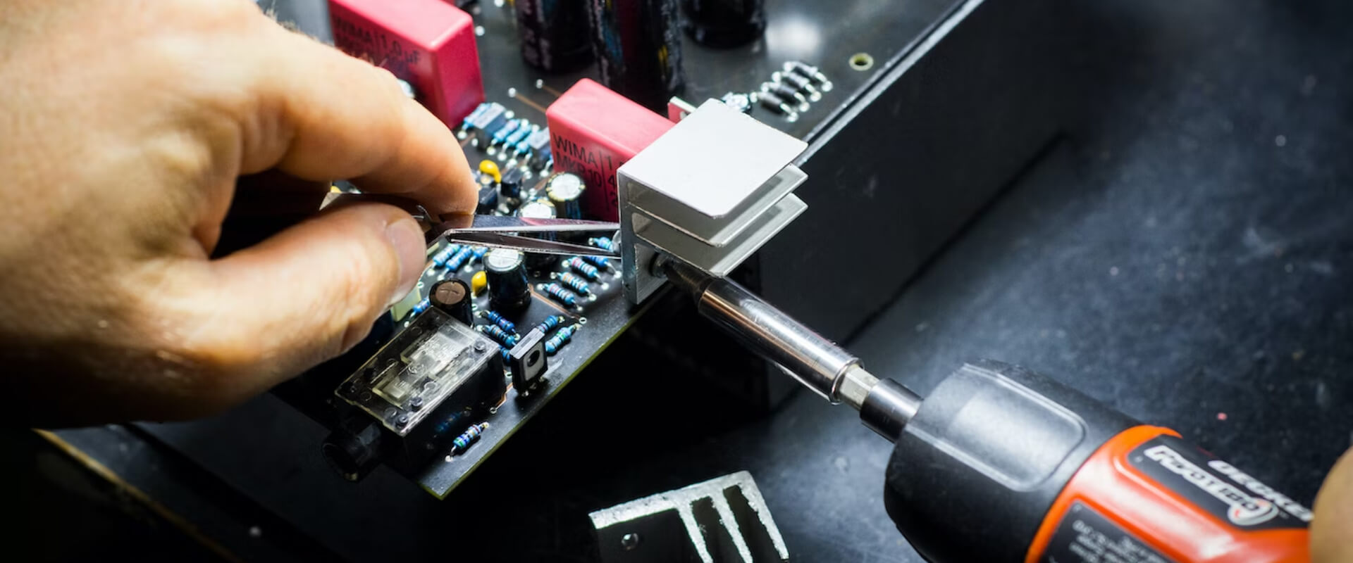 A technician assembling components on a printed circuit board